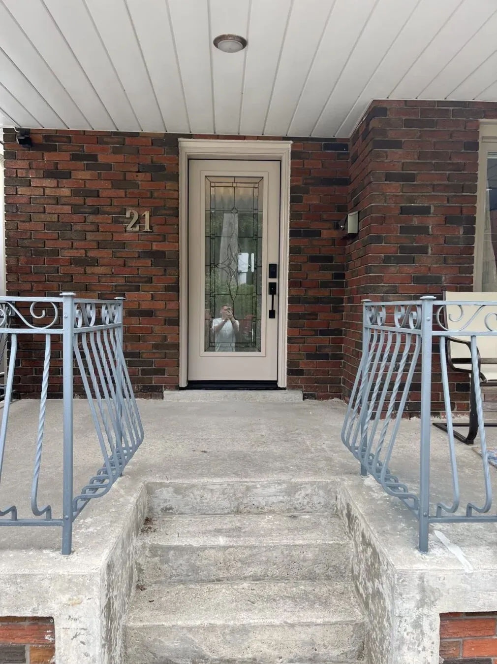 Decorative glass entry door with black hardware on a brick porch in Vaughan, Ontario
